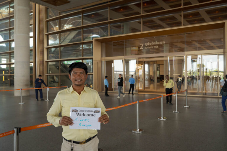 Phnom Penh airport transfer driver meeting passenger in arrivals area with name sign